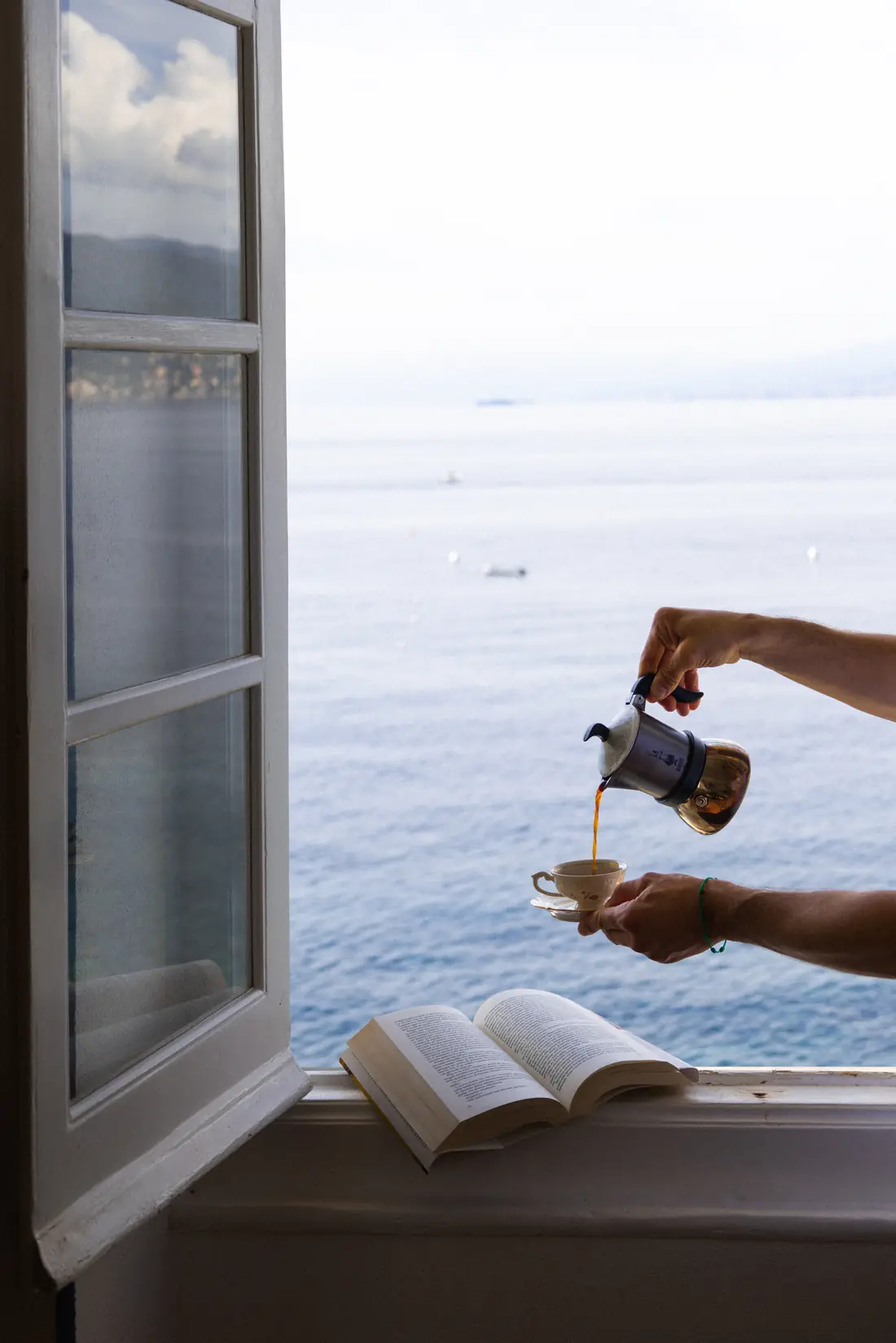 Coffee poured at an open window above the sea