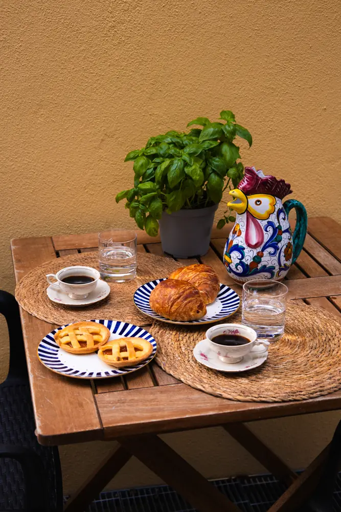 Breakfast with croissants and coffee on a table above the sea