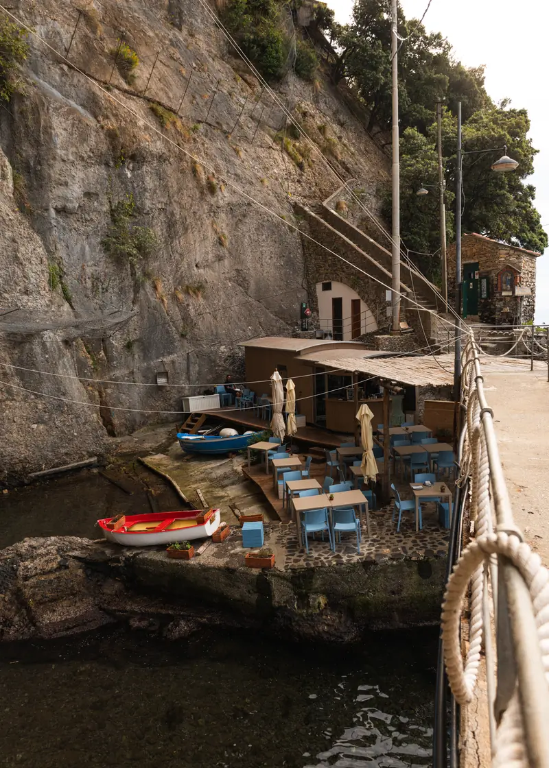 The small harbour of Porto Pidocchio with tables on the pier
