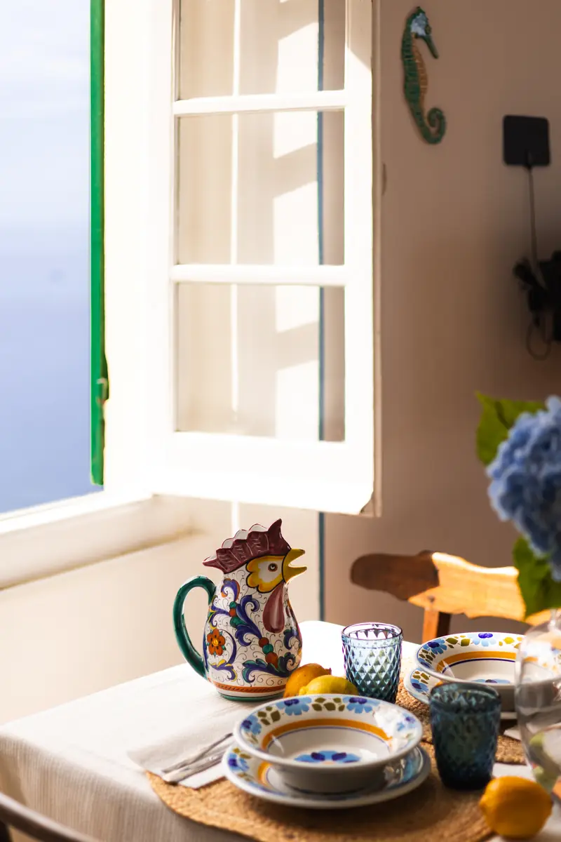 Table laid with ceramic plates and a rooster jug